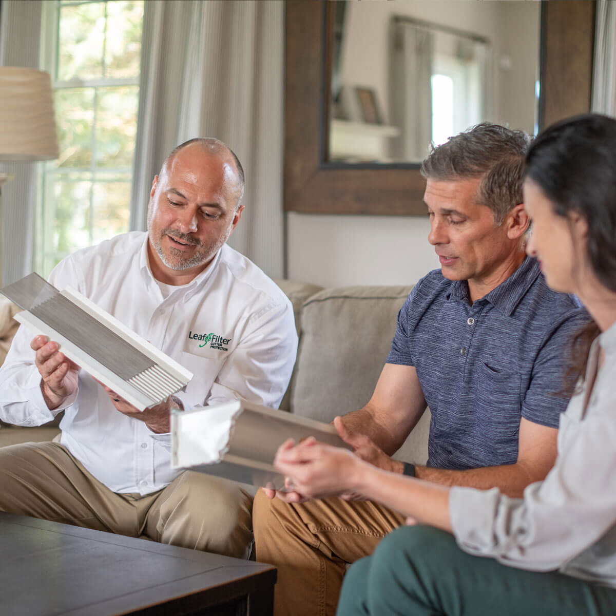 LeafFilter employee discussing gutters on a customer's home