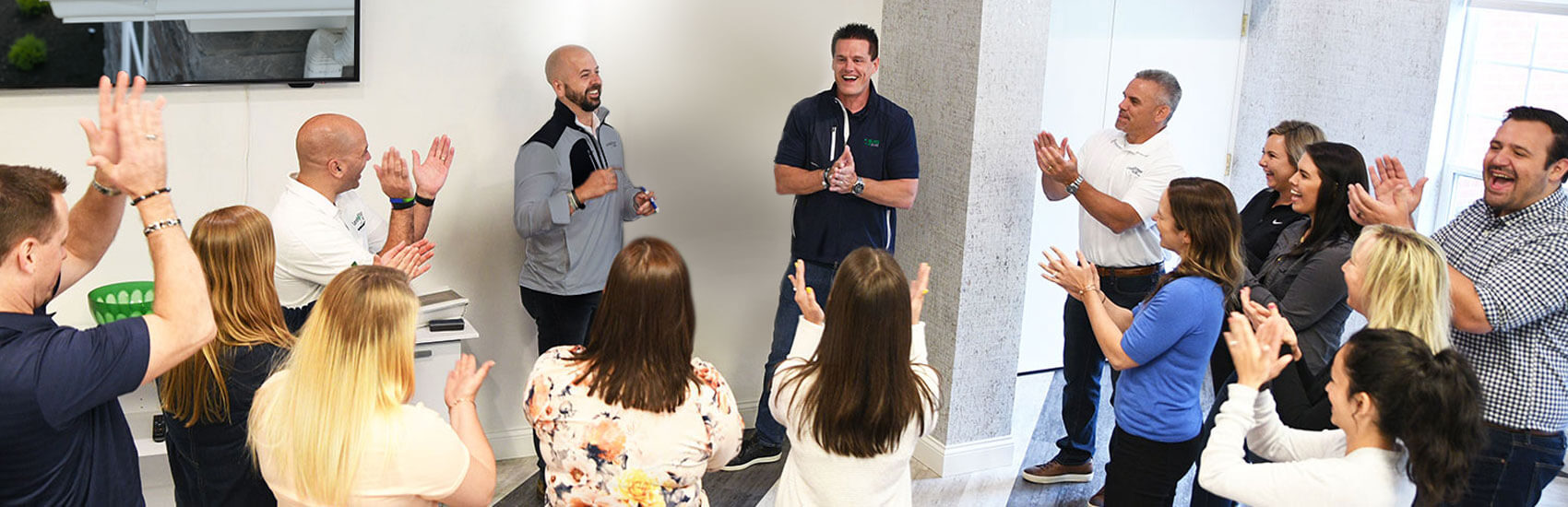 Members of the LeafFilter company applauding during a meeting